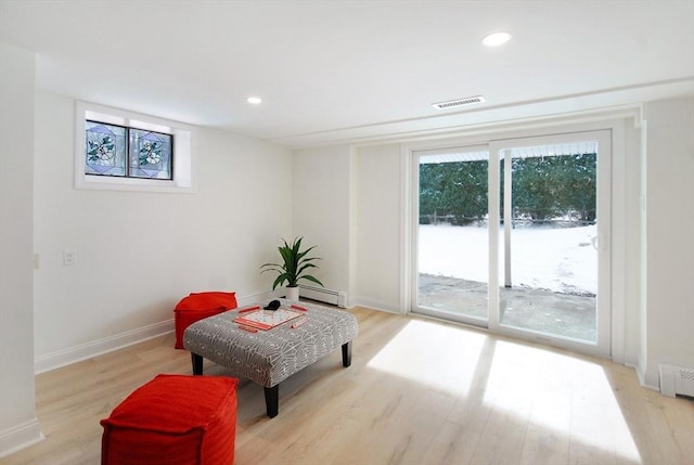 living area with light wood-style floors, visible vents, and recessed lighting