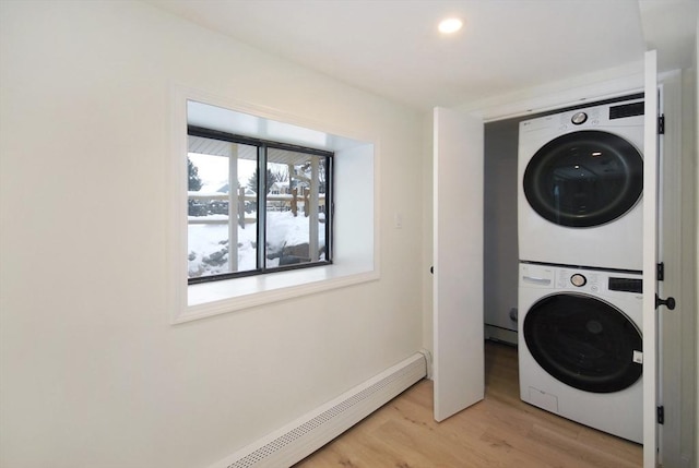 laundry area with a baseboard radiator, light wood-style flooring, recessed lighting, laundry area, and stacked washer / drying machine