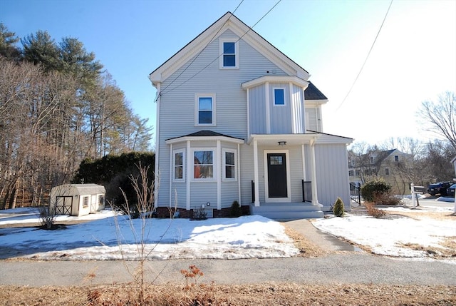 view of front of property with board and batten siding, an outbuilding, and a storage unit