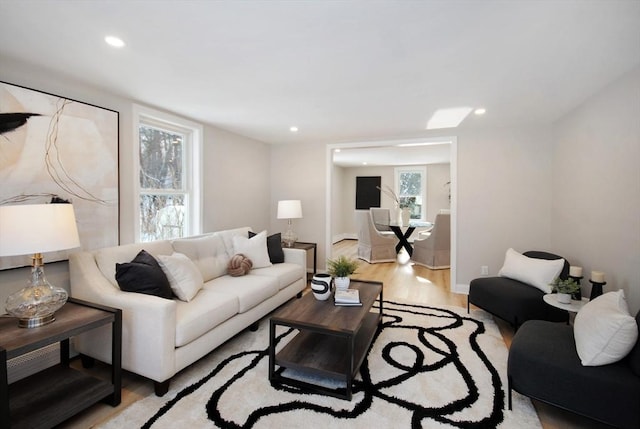 living area featuring light wood-type flooring, baseboards, and recessed lighting