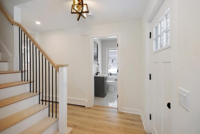 staircase with plenty of natural light, baseboards, wood finished floors, and recessed lighting