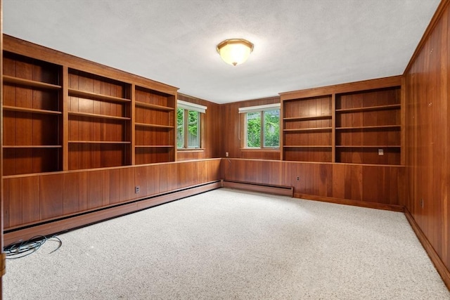 61 Sevland Rd, Newton, MA 02459 - empty room featuring wood walls, carpet, and a baseboard heating unit