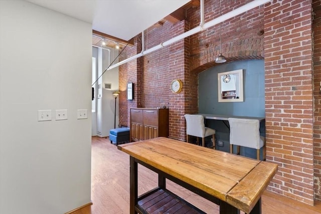 office space featuring brick wall and hardwood / wood-style floors