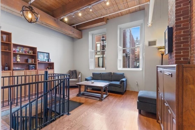 living room featuring wood-type flooring, rail lighting, wood ceiling, and beam ceiling