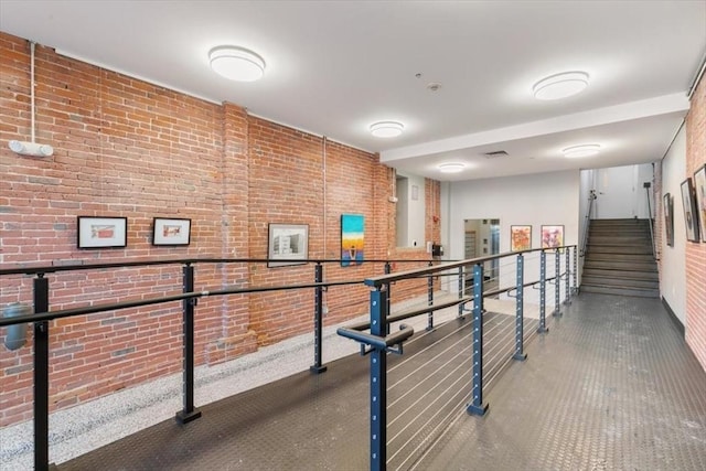 hallway featuring brick wall