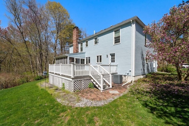 16 Parmenter Rd, Framingham, MA 01701 - back of property with a chimney, a lawn, a wooden deck, and a sunroom