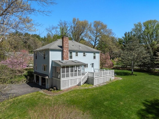 16 Parmenter Rd, Framingham, MA 01701 - back of house with a sunroom, a chimney, an attached garage, a deck, and a yard