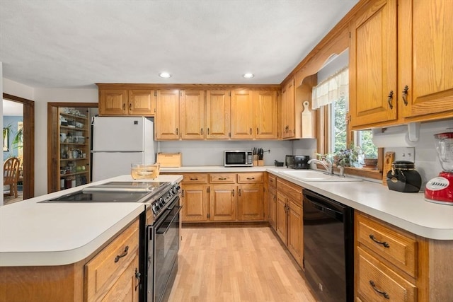 16 Parmenter Rd, Framingham, MA 01701 - kitchen with black appliances, light wood-style flooring, light countertops, brown cabinetry, and recessed lighting