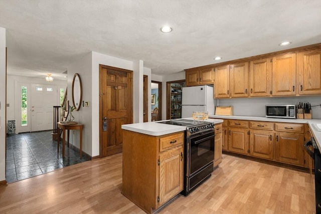 16 Parmenter Rd, Framingham, MA 01701 - kitchen featuring black appliances, light countertops, a kitchen island, recessed lighting, and light wood-type flooring