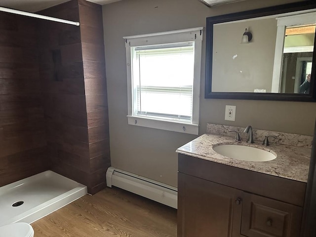 110 School St, Warren, MA 01083 - full bathroom featuring baseboard heating, a tile shower, wood finished floors, and vanity