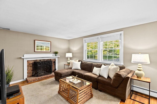 154 Mann Lot Rd, Scituate, MA 02066 - living room featuring a baseboard heating unit, a fireplace, baseboards, and wood finished floors