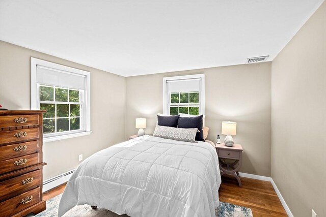 154 Mann Lot Rd, Scituate, MA 02066 - bedroom featuring a baseboard radiator, wood finished floors, and baseboards