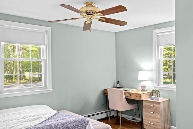 154 Mann Lot Rd, Scituate, MA 02066 - bedroom with a baseboard radiator, wood finished floors, a desk, ceiling fan, and baseboards