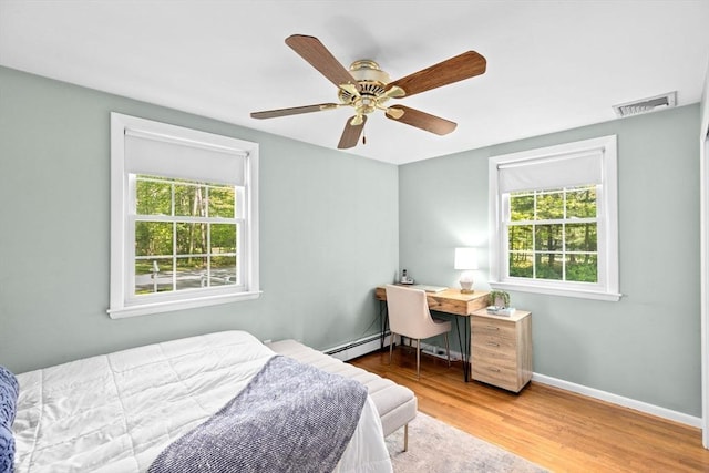 154 Mann Lot Rd, Scituate, MA 02066 - bedroom with multiple windows, baseboard heating, wood finished floors, and baseboards