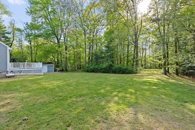154 Mann Lot Rd, Scituate, MA 02066 - view of grassy yard with a deck, a storage unit, and an outbuilding