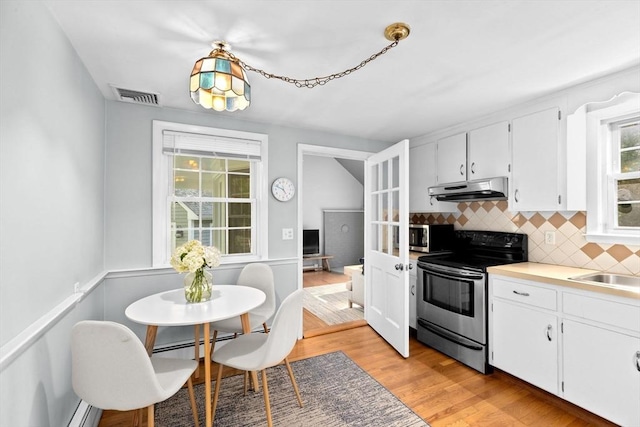 154 Mann Lot Rd, Scituate, MA 02066 - kitchen with appliances with stainless steel finishes, under cabinet range hood, tasteful backsplash, light wood finished floors, and white cabinets