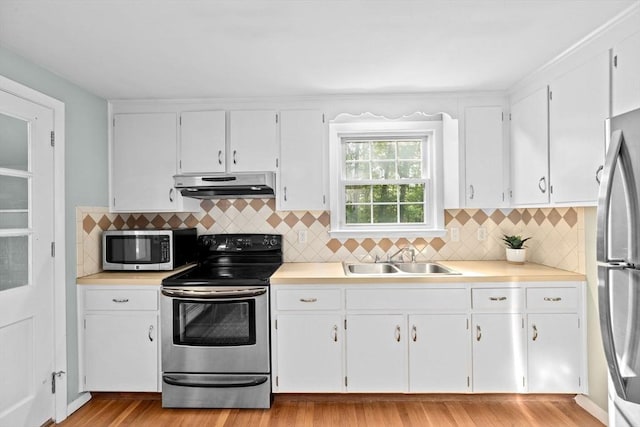 154 Mann Lot Rd, Scituate, MA 02066 - kitchen featuring appliances with stainless steel finishes, under cabinet range hood, a sink, and light countertops