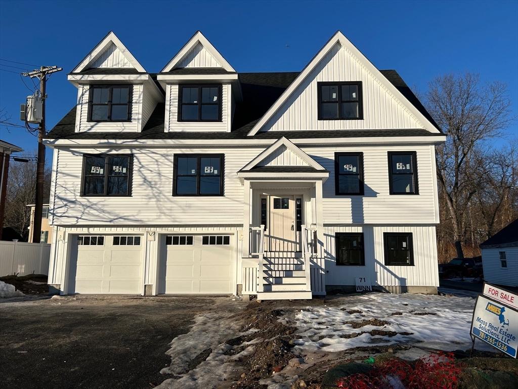 view of front of home with an attached garage, dirt driveway, fence, and board and batten siding