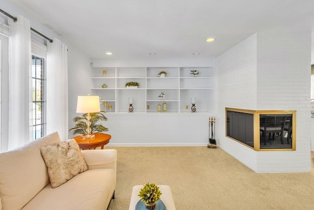 carpeted living room featuring built in features, recessed lighting, a brick fireplace, and baseboards