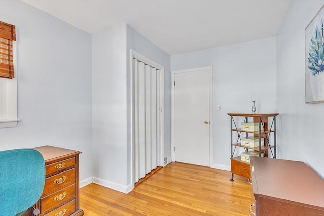 office area featuring baseboards and light wood finished floors