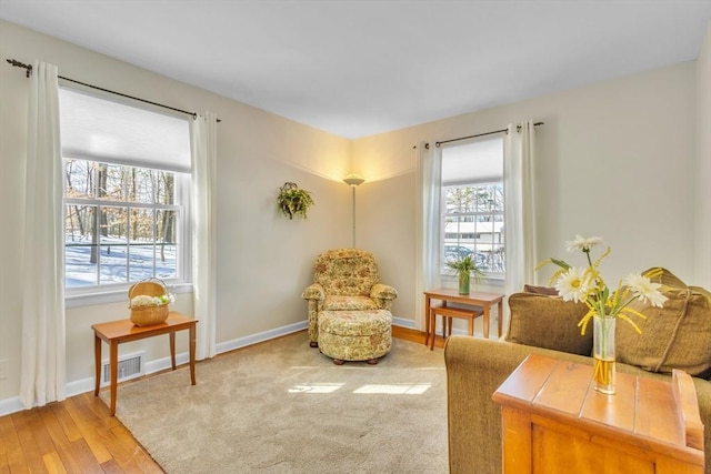 living area with visible vents, baseboards, and light wood finished floors