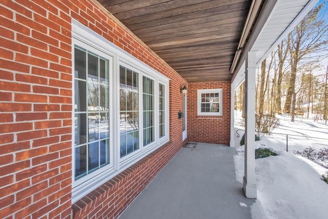 snow covered patio with covered porch