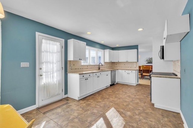 kitchen with baseboards, a sink, stainless steel appliances, white cabinetry, and tasteful backsplash