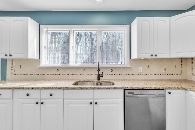 kitchen with dishwasher, backsplash, white cabinetry, and a sink