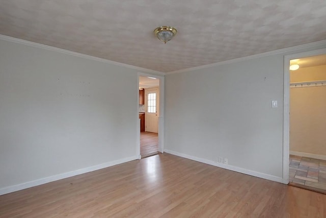 empty room featuring light hardwood / wood-style flooring and crown molding