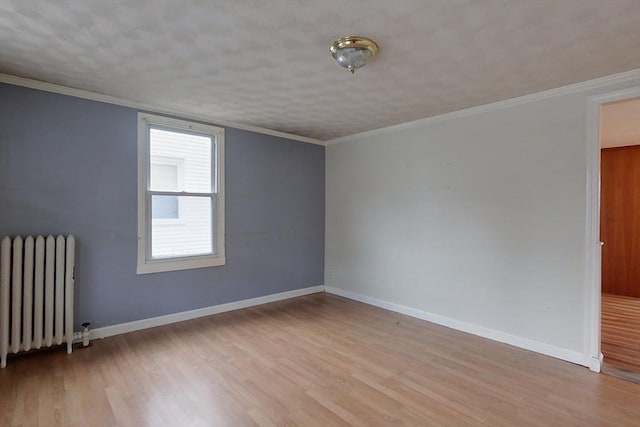 spare room with light hardwood / wood-style floors, radiator heating unit, and crown molding