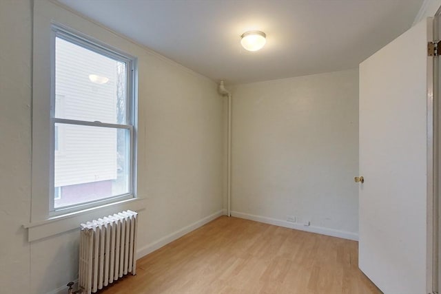 spare room with light wood-type flooring and radiator