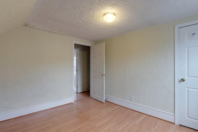 unfurnished room featuring light hardwood / wood-style floors and a textured ceiling