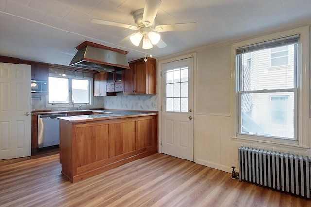 kitchen featuring kitchen peninsula, a wealth of natural light, radiator, dishwasher, and light hardwood / wood-style floors