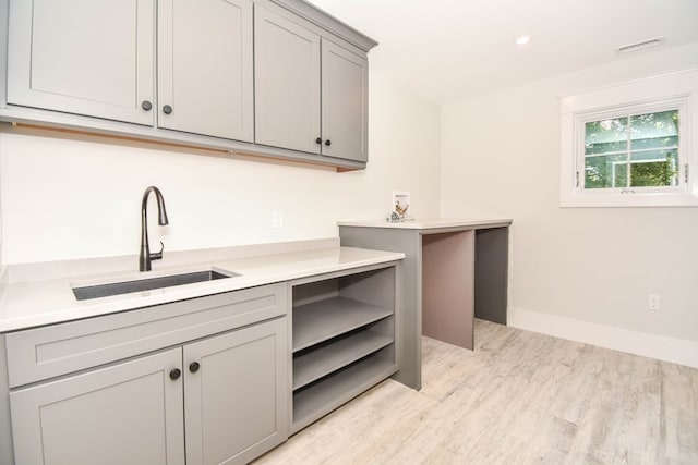 kitchen featuring gray cabinetry, sink, and light hardwood / wood-style floors