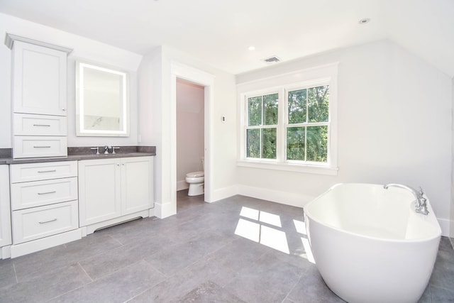 bathroom featuring a bathing tub, vanity, and toilet