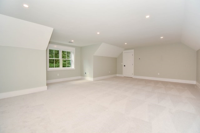 bonus room featuring vaulted ceiling and light colored carpet