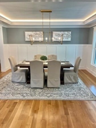 dining space with hardwood / wood-style floors and a tray ceiling