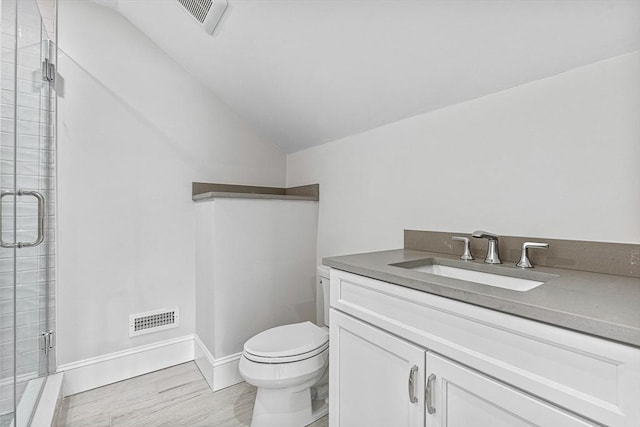 bathroom with vanity, vaulted ceiling, a shower with shower door, and toilet