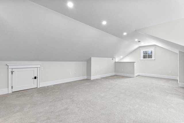 additional living space with vaulted ceiling and light colored carpet