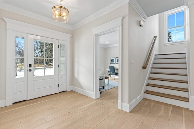 foyer entrance with light wood-type flooring, crown molding, and plenty of natural light