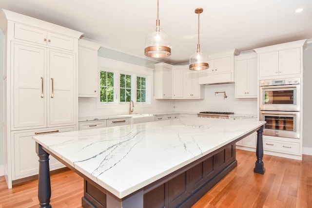 kitchen featuring a large island, hanging light fixtures, a breakfast bar, and appliances with stainless steel finishes