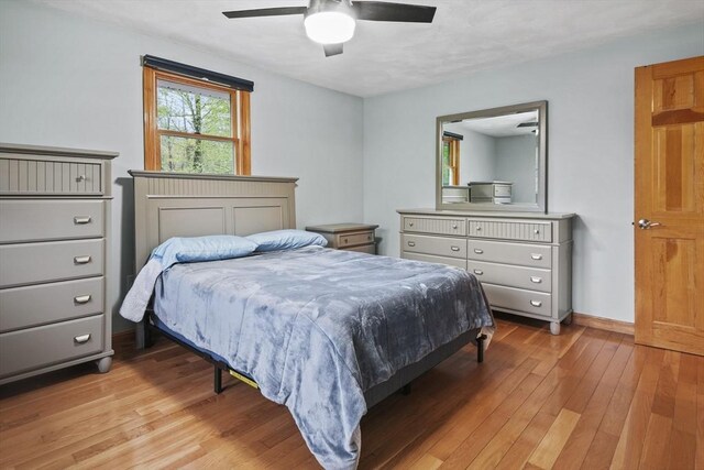 bedroom featuring light wood-style floors, baseboards, and ceiling fan