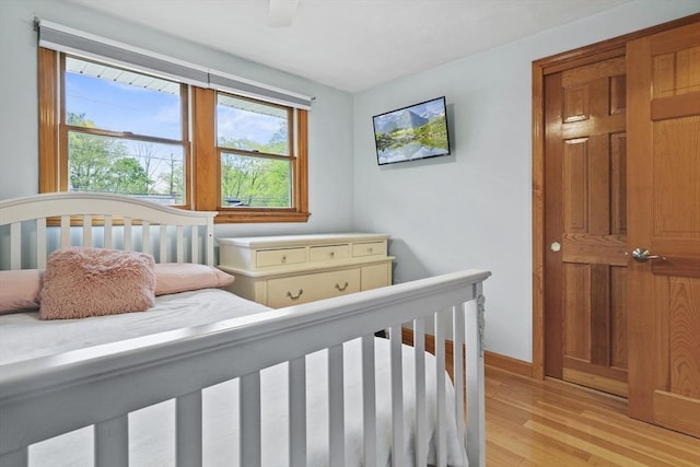 bedroom featuring light wood finished floors, baseboards, and a ceiling fan