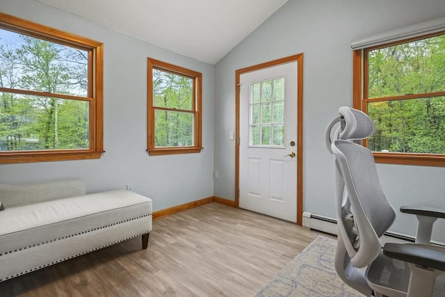 office area featuring baseboard heating, lofted ceiling, light wood-type flooring, and baseboards