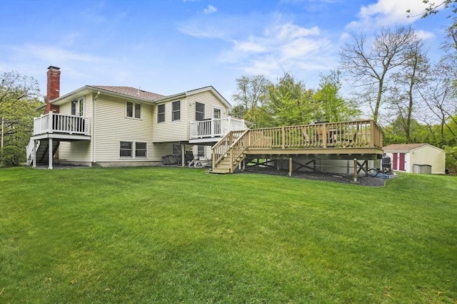 back of property featuring stairs, a wooden deck, a chimney, a storage unit, and an outdoor structure