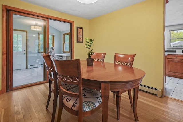 dining room featuring a baseboard heating unit and light wood-type flooring