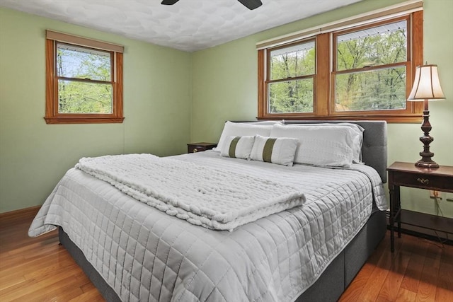 bedroom featuring wood finished floors, a ceiling fan, and baseboards
