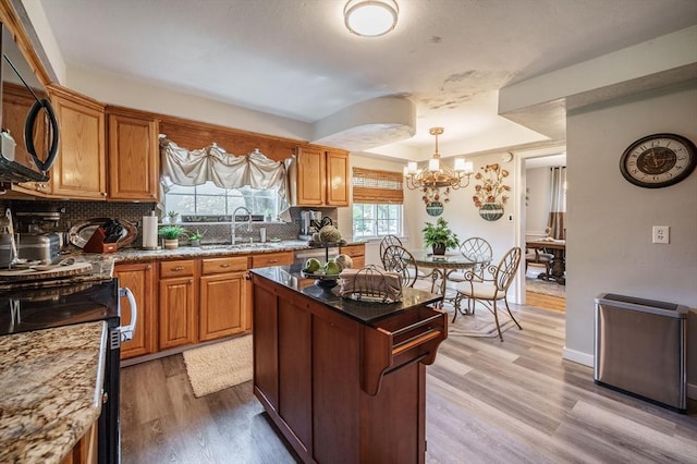 kitchen featuring a sink, backsplash, stainless steel electric range, a chandelier, and black microwave