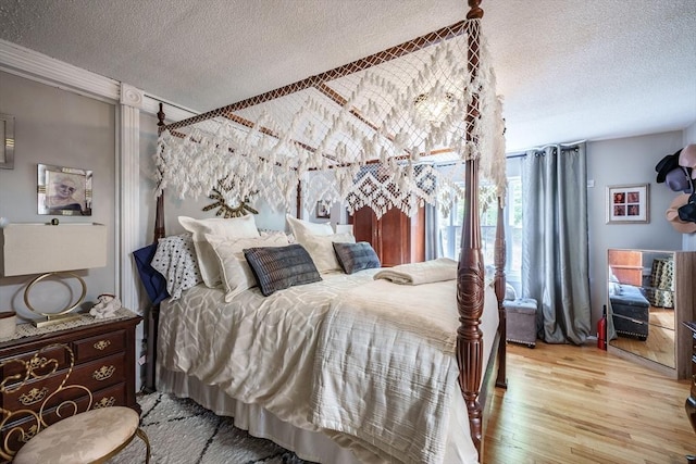 bedroom with a textured ceiling and wood finished floors
