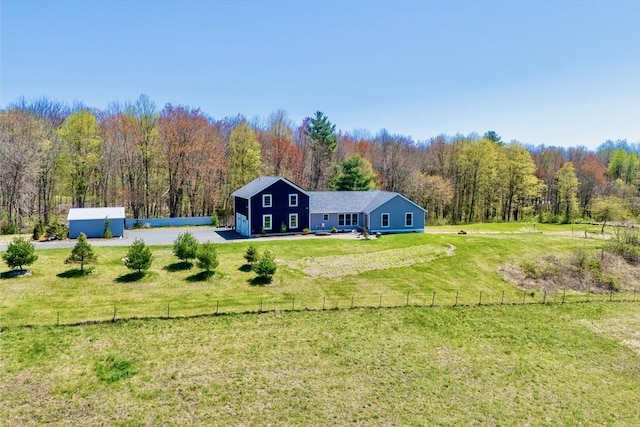 exterior space with a lawn, fence, and a forest view